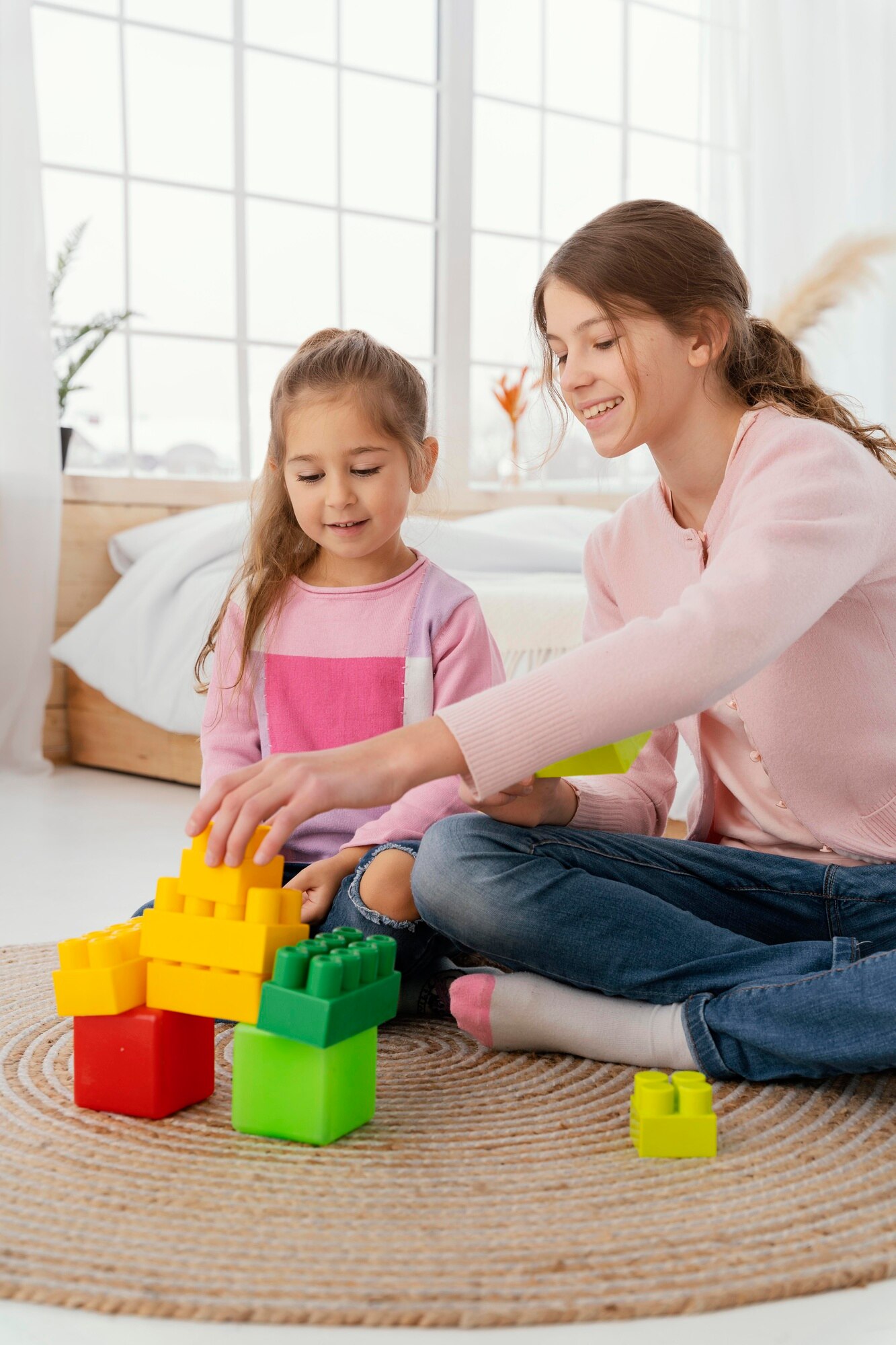 vista-frontal-dos-hermanas-jugando-juguetes-casa_23-2148890917